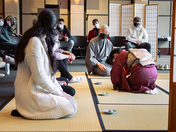 A class of students watch a traditional Japanese tea ceremony demonstration.